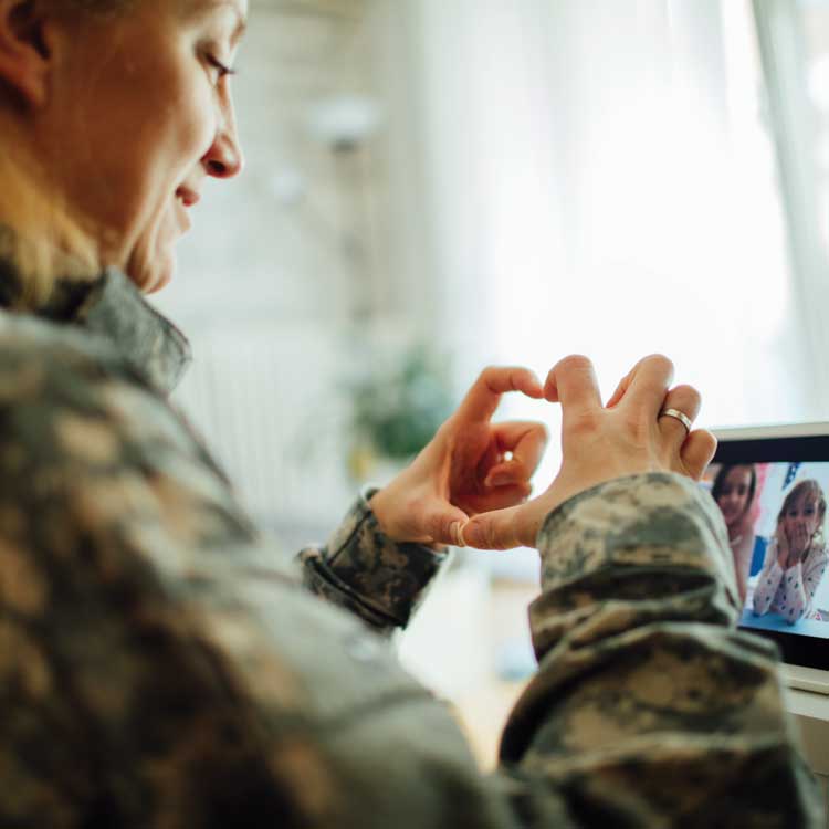 military member on computer with family 